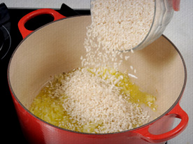 Numa panela doure a cebola na manteiga, acrescente o arroz e refogue um pouco.