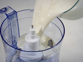 Coloque a coalhada e a água gelada num processador (ou batedeira) e misture por 5 minutos. (Caso queira incorporar o creme de leite nesta receita, este é o momento de misturar e bater mais um pouco. Você também pode bater o creme separadamente e o acrescentar na sopa finalizada).